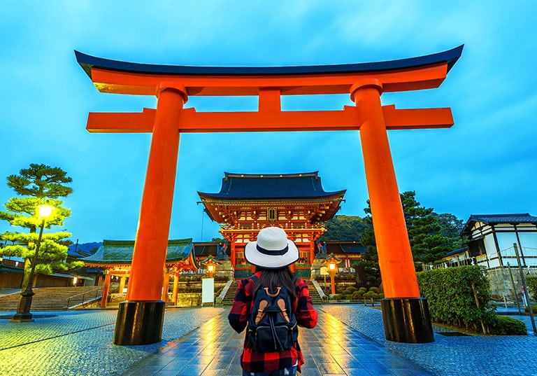 Mujer frente a un torii: es un arco o puerta tradicional japonés que marca la entrada a los santuarios sintoístas. Simboliza la transición del mundo terrenal y cotidiano al espacio sagrado y espiritual