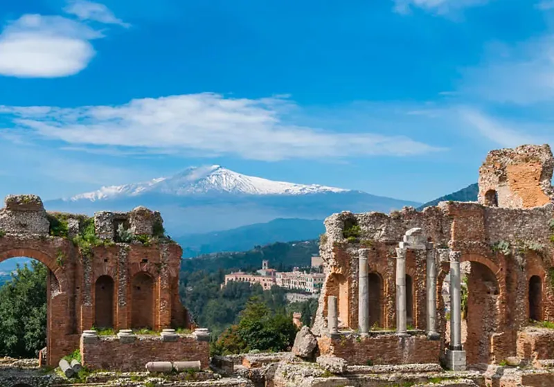 Vista del Teatro Antiguo de Taormina con el volcán Etna al fondo, destino exclusivo en los tours por Italia de Lobato Tours