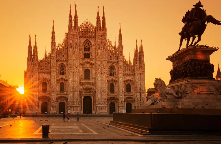 El Duomo di Milano en Milán es una catedral gótica de mármol blanco, llena de agujas, estatuas y detalles tallados, coronada por la brillante estatua dorada de la Madonnina.