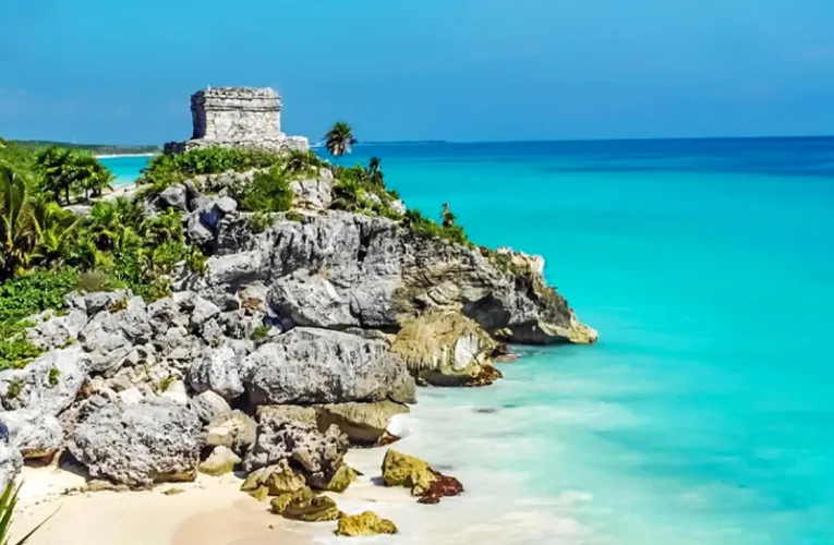 Playa de la Riviera Maya con arena blanca, mar turquesa y palmeras en un entorno tropical.