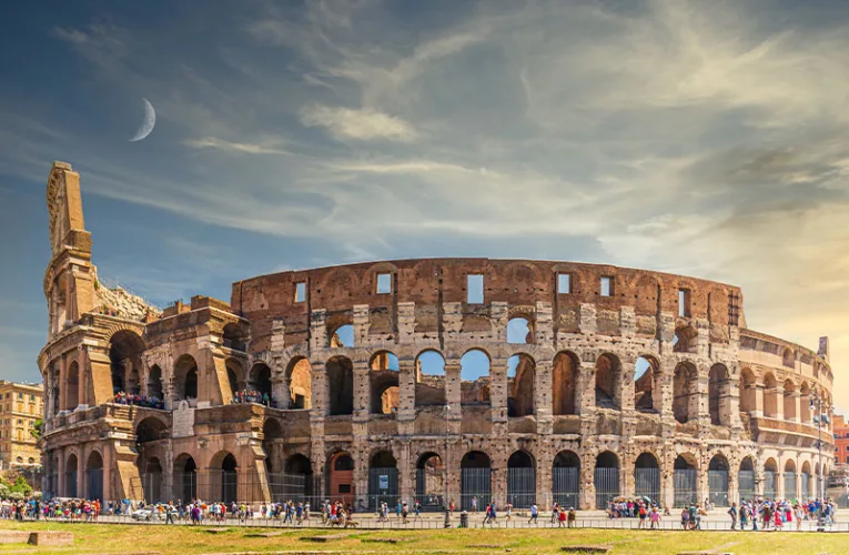 El Coliseo en Roma es un imponente anfiteatro de piedra, con arcos superpuestos y una estructura monumental que evoca la grandeza del Imperio romano.